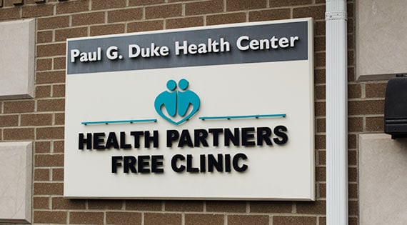 Entry door sign that says "Health Partners Free Clinic".